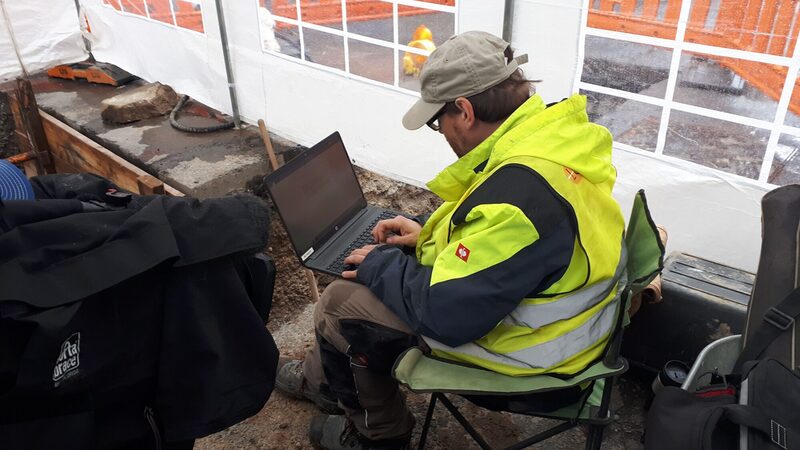 Ein Mitarbeiter dokumentiert die Funde in der Baugrube.