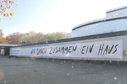 Bild vom zukünftigen Pina Bausch Zentrum im ehemaligen Schauspielhaus mit dem Banner "Wir bauen zusammen ein Haus"